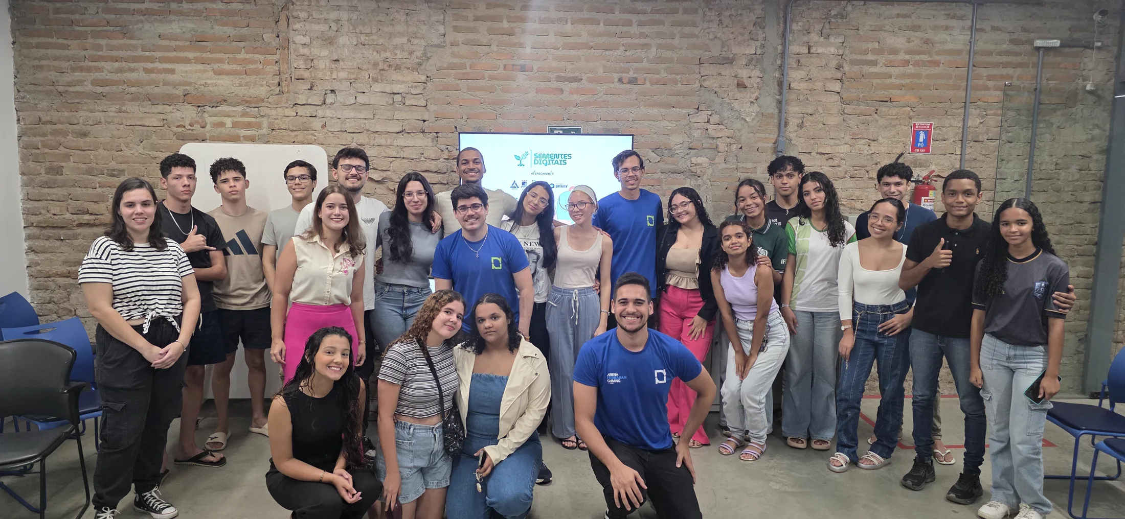 Grupo do projeto Sementes Digitais reunido em frente à apresentação do projeto